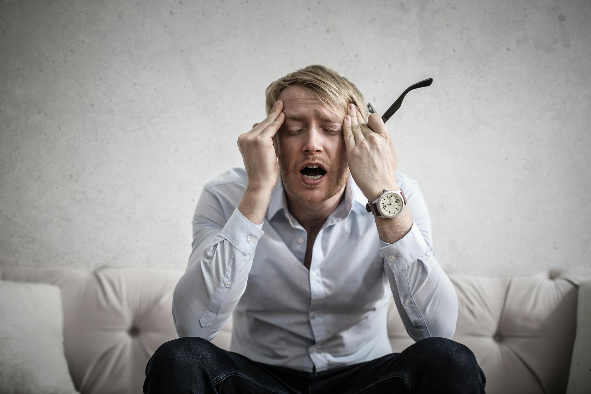 Homme qui se tient la tête (fatigue émotionnelle)