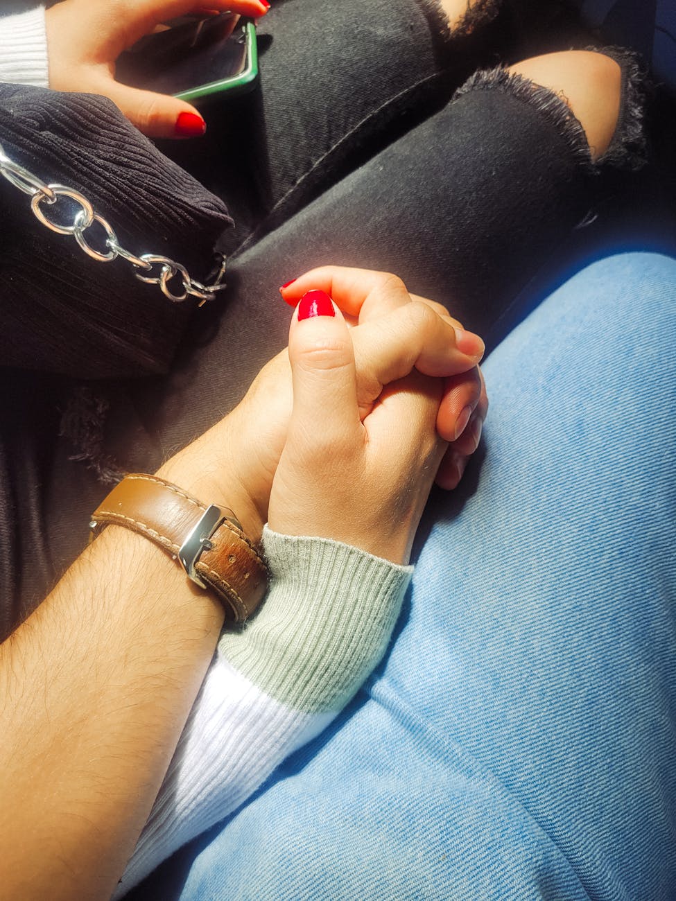 Le toucher comme soutien : apaiser et réconforter grâce au massage 2 Gros plan d'un couple en jeans qui se tient la main (toucher comme soutien)