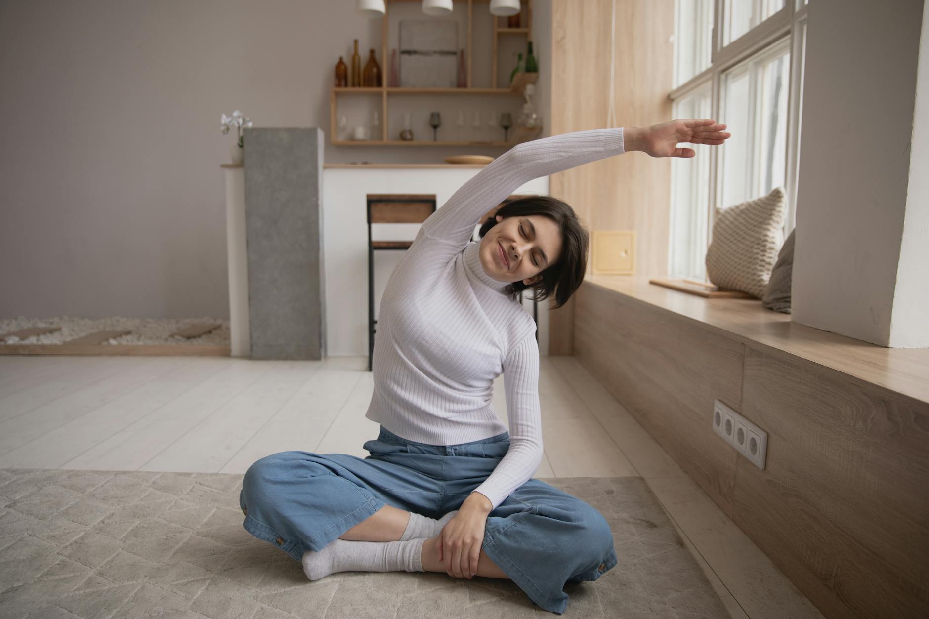 Femme souriante qui s'étire avec ls yeux fermés (massage et cicatrices)