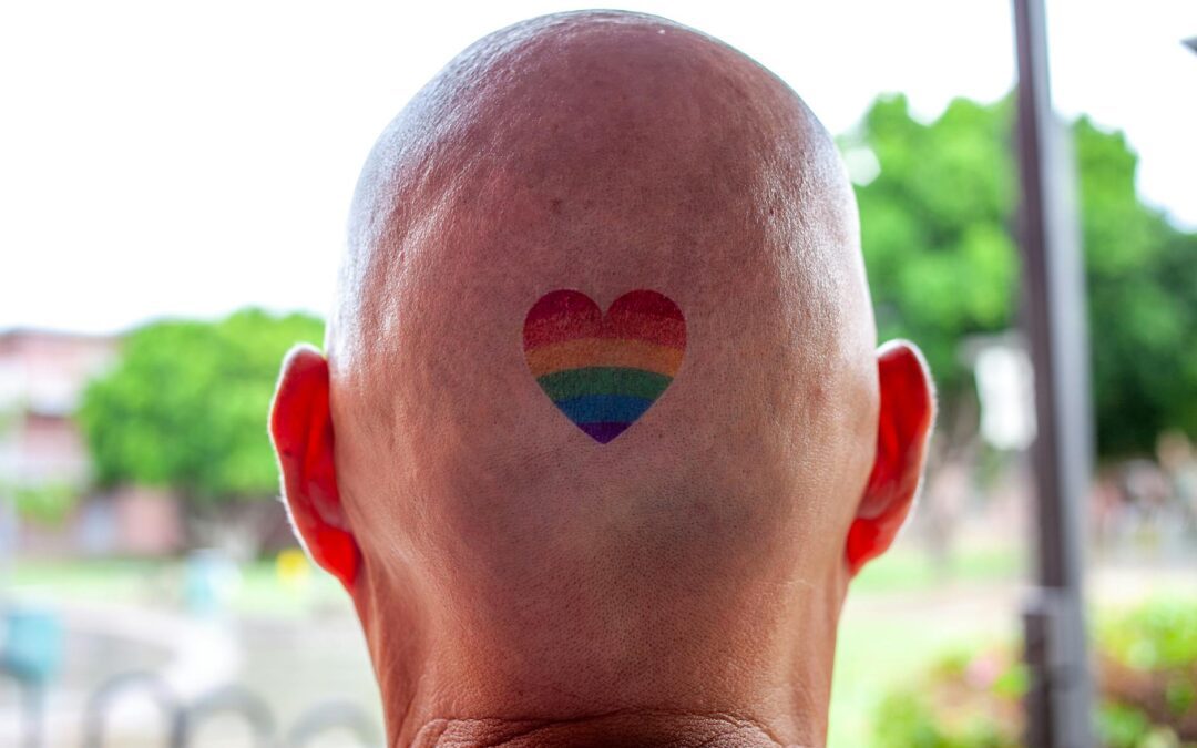 person with heart rainbow tattoo on scalp