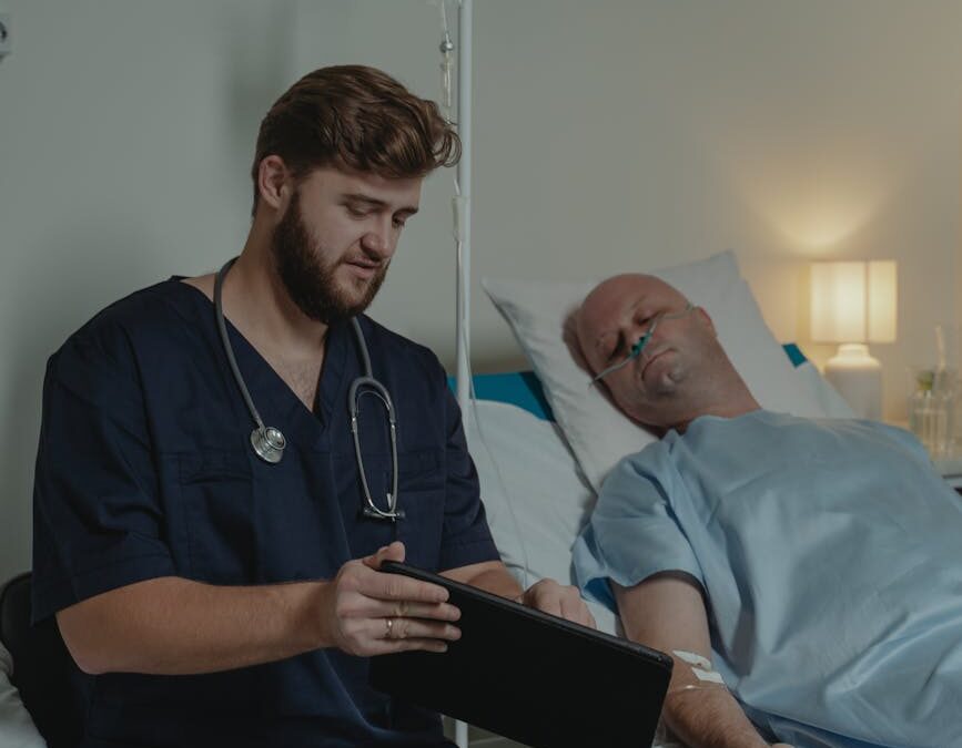 man in blue scrub suit showing a patient a digital tablet