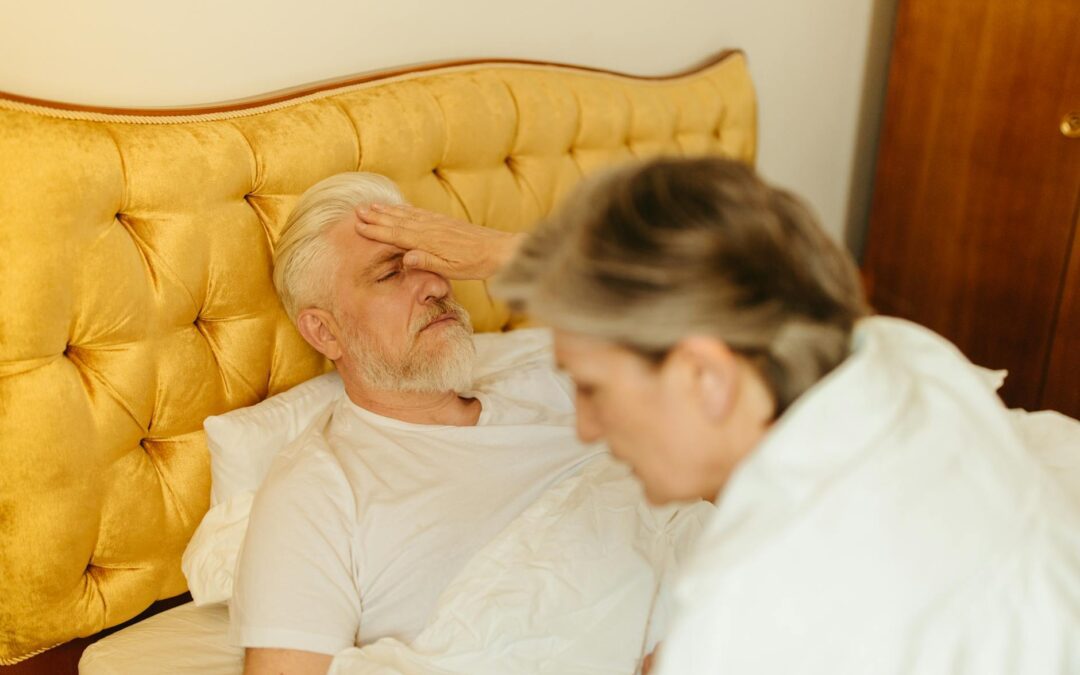 elderly man lying down on bed looking sick