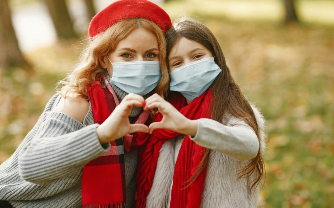woman and girl making a heart symbol with hands