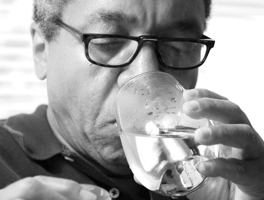 man drinking a glass of water